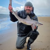 Sea Angler holding smoothhound in vass 220 winter waterproofs and waders
