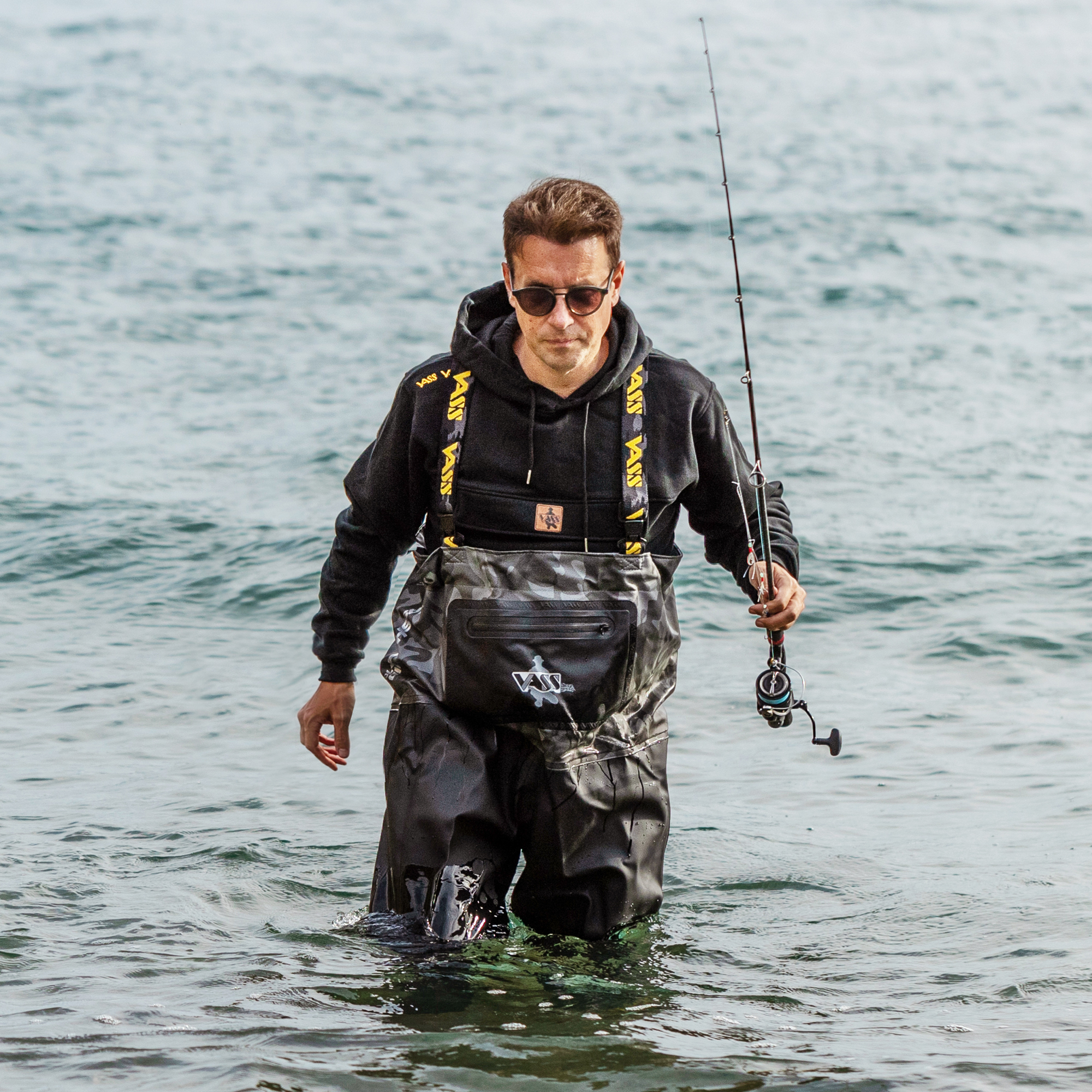Bass angler wearing Vass Hybrid 700 chest waders while lure fishing